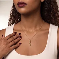 A woman wearing a white sleeveless top and a silver curved pendant necklace, with dark burgundy nail polish and curled dark hair.