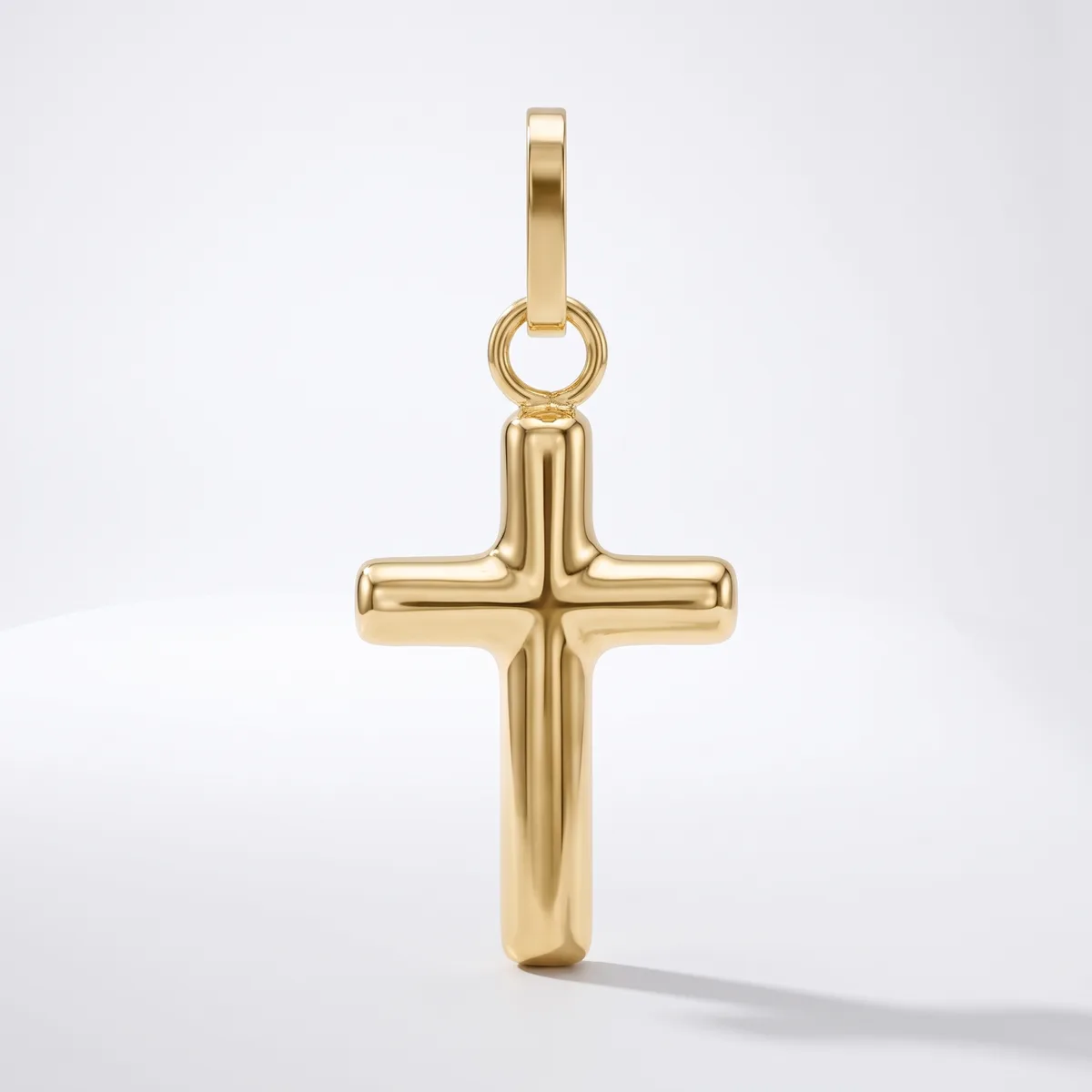 A polished gold cross pendant with a rounded rectangular bail attached to the top, displayed against a white background.