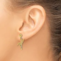 A gold-toned parrot charm earring hanging from a ball post on a person's earlobe.