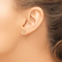 A person wearing a small butterfly-shaped stud earring with gemstones in the earlobe, shown from the side profile.