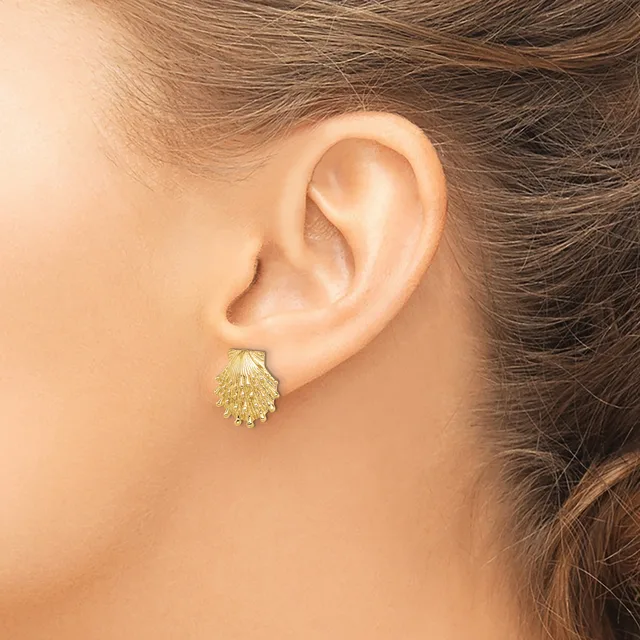 A gold textured teardrop-shaped stud earring worn on a person's earlobe, shown in profile view.