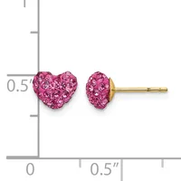 A pair of pink crystal heart-shaped stud earrings with gold posts displayed on a measurement scale.