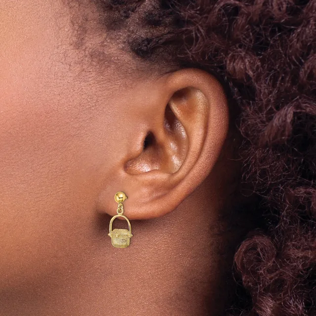 A person wearing a gold-toned drop earring with a small ball post and a textured rectangular pendant hanging below, shown from the side view of their ear.