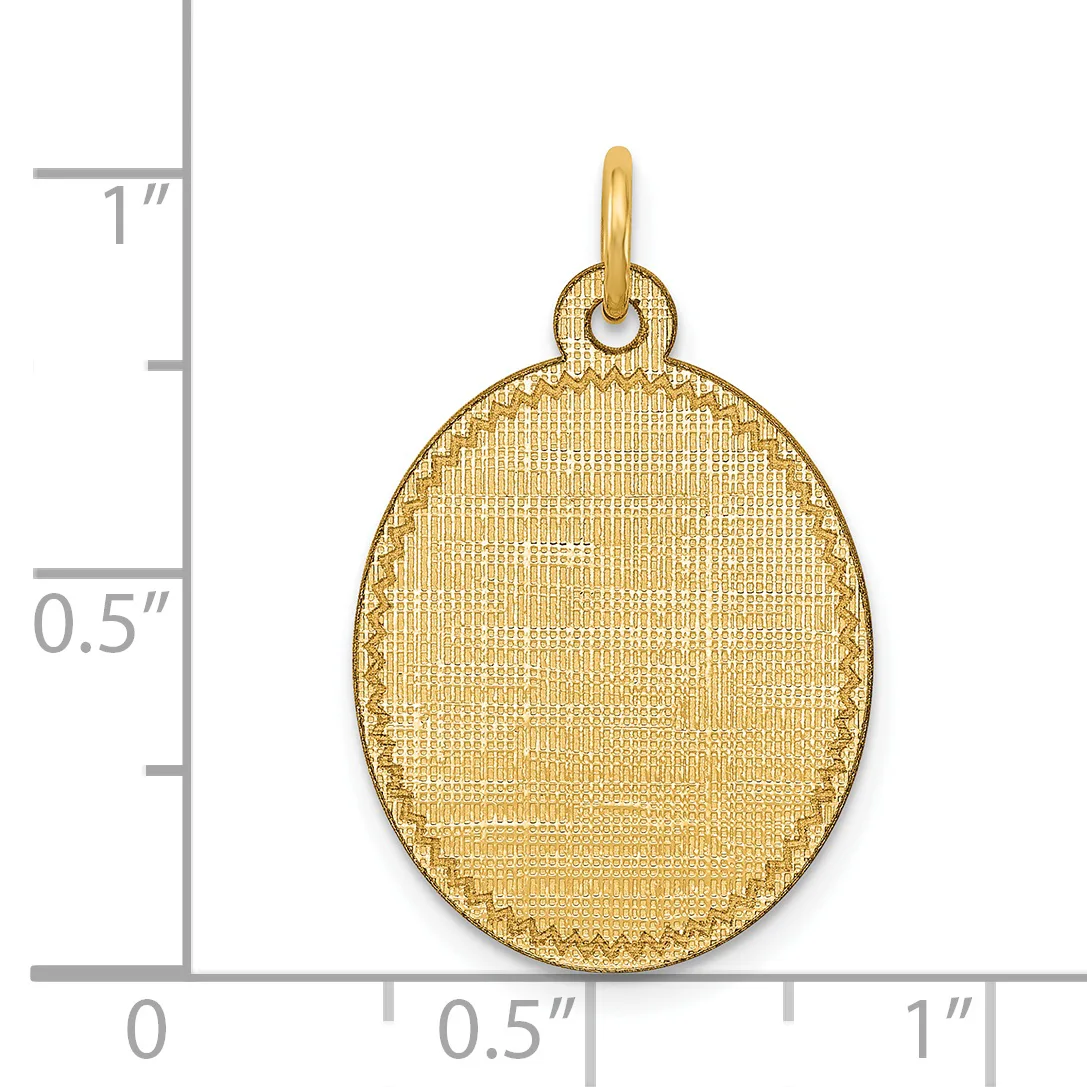 A gold-toned oval pendant with textured surface and small hallmark, displayed against a ruler showing approximately one inch in height.