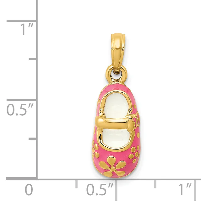 A gold baby shoe charm with pink enamel coating and gold flower designs, shown next to a ruler for scale.