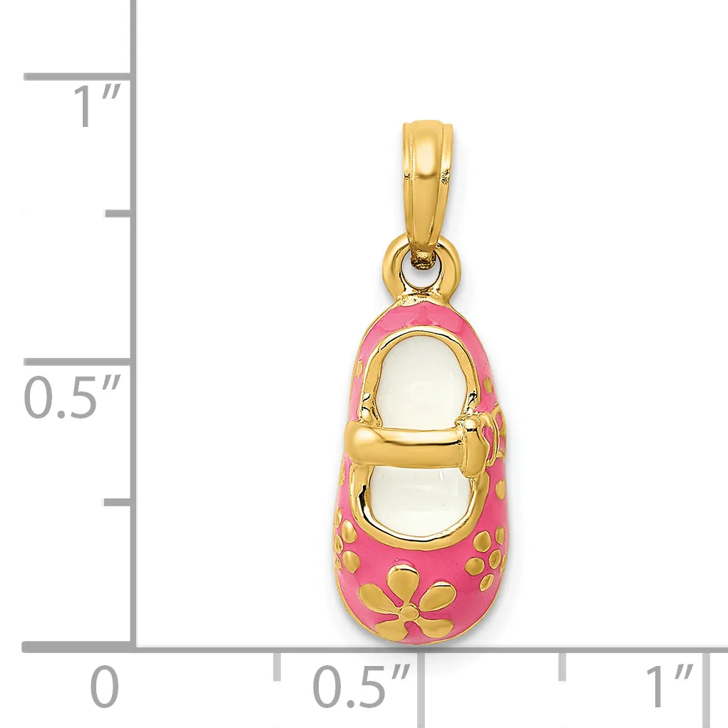 A gold baby shoe charm with pink enamel coating and gold flower designs, shown next to a ruler for scale.