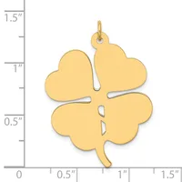 A gold four-leaf clover charm with a loop at the top, shown next to a ruler indicating it measures approximately one inch wide and one and a quarter inches tall.