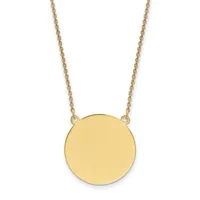 A gold-colored circular pendant hangs from a delicate gold chain against a white background.