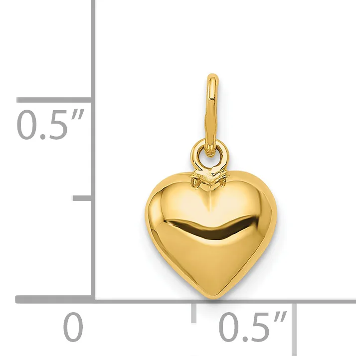 A polished gold-colored heart-shaped pendant with a small loop at the top, shown next to a ruler indicating it is approximately 0.5 inches wide.