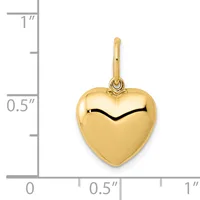 A polished gold heart-shaped pendant with a small loop at the top, shown next to a ruler indicating it measures approximately half an inch wide.