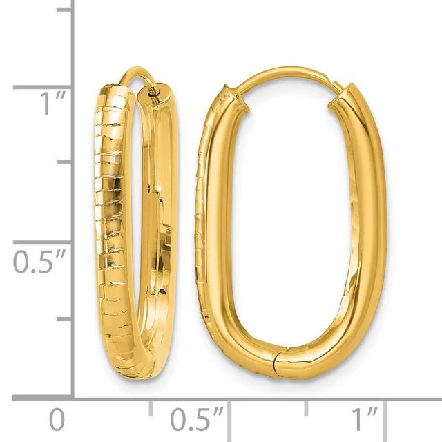 Two gold-toned oval hoop earrings with textured and polished surfaces, displayed next to a measurement ruler showing approximately one inch in height.