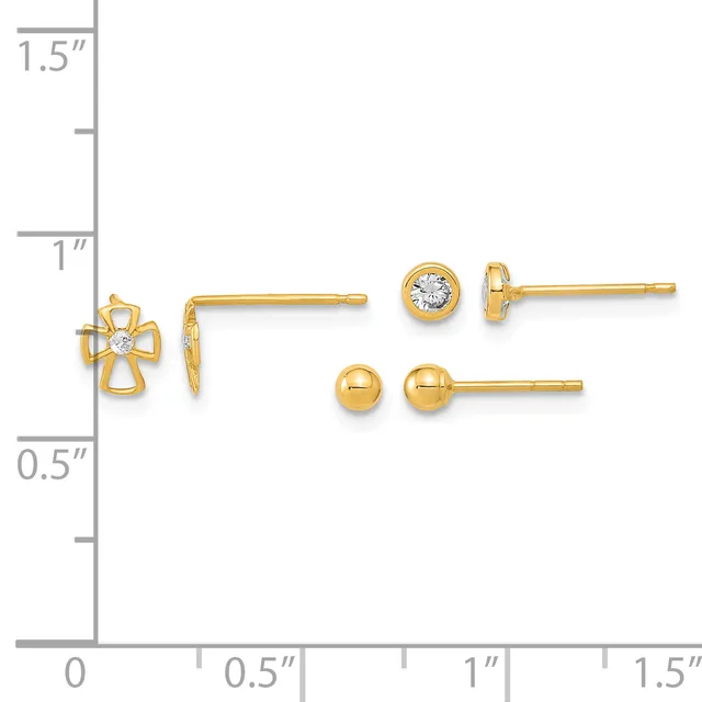 Three pairs of gold earrings displayed on a measurement scale: a cross design with a center stone, a round bezel-set stone stud, and a polished ball stud.