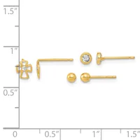 Three pairs of gold earrings displayed on a measurement scale: a cross design with a center stone, a round bezel-set stone stud, and a polished ball stud.