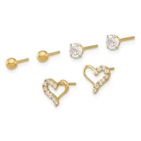 Three pairs of gold stud earrings displayed in a row: small polished gold spheres, oval-cut cubic zirconia stones, and heart shapes outlined with small cubic zirconia stones.