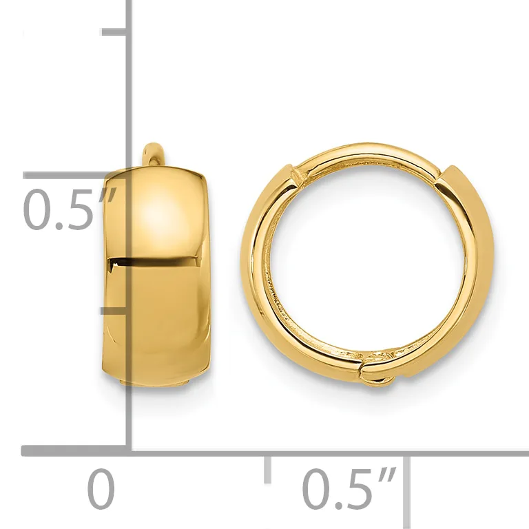 A pair of polished gold huggie hoop earrings displayed next to a ruler showing their dimensions of approximately 0.5 inches in height and width.