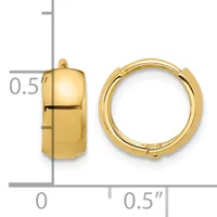 A pair of polished gold huggie hoop earrings displayed next to a ruler showing their dimensions of approximately 0.5 inches in height and width.