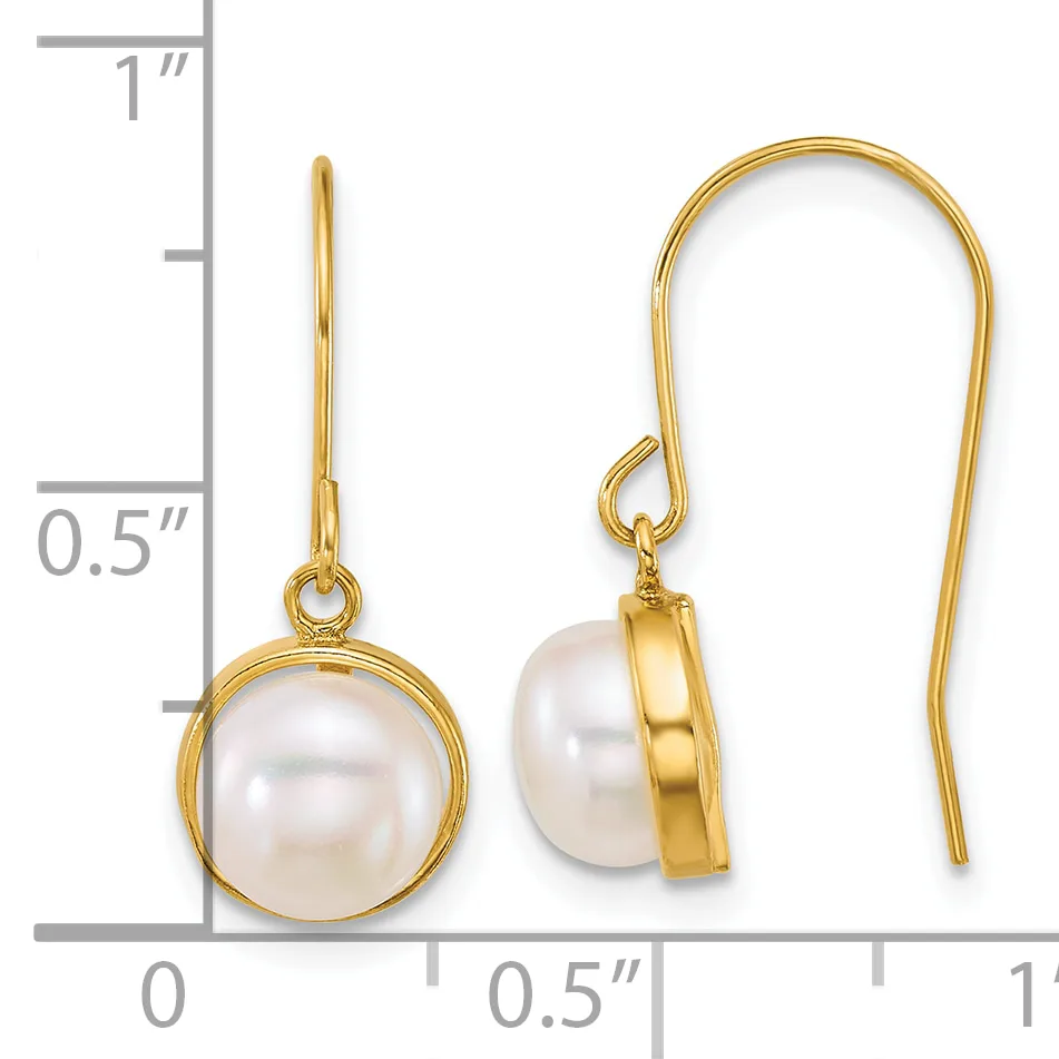 Gold-toned fishhook earrings with white pearl drops, displayed on a ruler showing approximately one inch in length.