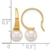 A pair of gold fishhook earrings with white pearl drops, shown next to a ruler indicating approximately half-inch length.