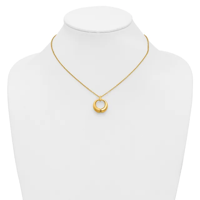 A gold-toned chain necklace with a circular pendant featuring concentric rings, displayed on a white mannequin bust.