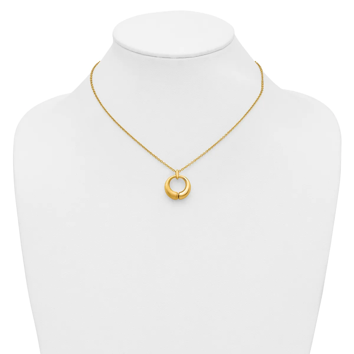 A gold-toned chain necklace with a circular pendant featuring concentric rings, displayed on a white mannequin bust.