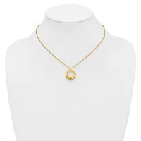 A gold-toned chain necklace with a circular pendant featuring concentric rings, displayed on a white mannequin bust.