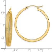 Pair of gold hoop earrings with a textured finish, shown from front and side views against a measurement scale indicating approximately 1.5 inches in diameter.