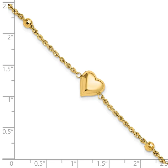 Gold-toned bracelet with twisted chain links, a polished puffy heart charm in the center, and small beads at each end, displayed against a ruler showing approximately 2.5 inches in length.