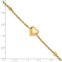 Gold-toned bracelet with twisted chain links, a polished puffy heart charm in the center, and small beads at each end, displayed against a ruler showing approximately 2.5 inches in length.