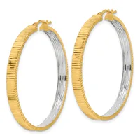 A pair of gold and silver two-tone hoop earrings with textured surfaces and hinged closures, displayed side by side.
