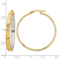 Two-tone gold and silver textured hoop earrings with ridged surfaces, shown next to a ruler indicating approximately one-inch diameter.