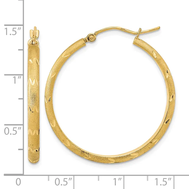 Gold hoop earrings with a textured finish and diamond-cut pattern, measuring 1.5 inches in length, displayed next to a measurement scale.