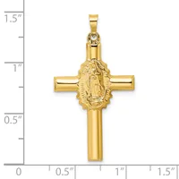 Gold cross pendant with an oval medallion featuring a relief figure in the center, shown against a measurement scale indicating approximately 1.5 inches in height.