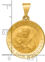 Gold pendant medal featuring two figures with a child, surrounded by text on the rim, shown next to a measurement scale.
