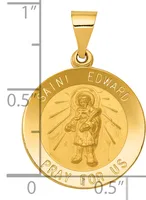 Gold-colored round medal pendant with Saint Edward holding a child, surrounded by radiating lines, with text around the border and a small hallmark, shown next to a ruler for scale.