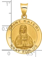 Gold round pendant featuring a portrait of Saint Kateri with text around the border, shown next to a ruler indicating approximately one inch in diameter.
