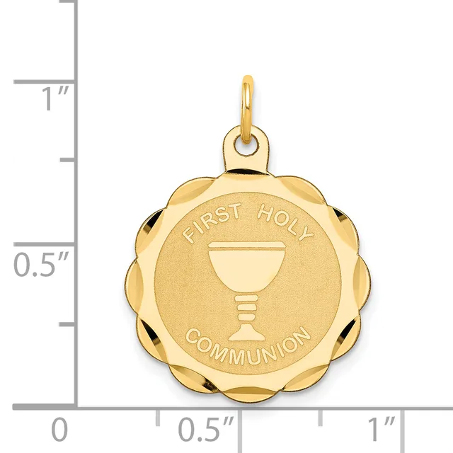Gold scalloped circular pendant with "First Holy Communion" text and chalice symbol, shown next to a measurement ruler indicating approximately one inch in diameter.