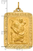 Gold rectangular pendant with rounded corners featuring Saint Christopher carrying Christ child in relief, surrounded by decorative border with text, shown next to ruler for scale.