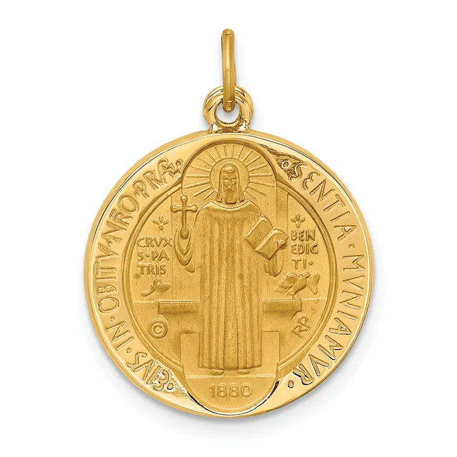 Gold round medallion pendant featuring a standing robed saint figure with a halo, holding a cross and book, surrounded by Latin text and decorative border, with a small stamped hallmark and date.