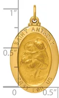 Gold oval pendant depicting Saint Anthony holding a child, with text around the border and a small loop at the top for hanging, shown next to a ruler for scale.