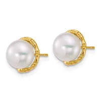 A pair of gold stud earrings featuring large white pearls set in textured gold bezels with post and butterfly backs.