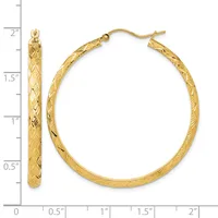 A pair of gold textured hoop earrings displayed next to a measurement ruler showing they are approximately 1.5 inches in diameter.