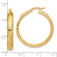 Pair of twisted gold hoop earrings with hinged posts, displayed against a measurement scale showing approximately 1.25 inches in diameter.