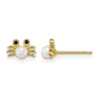 A pair of gold crab-shaped stud earrings with white pearl bodies, black onyx eyes, and textured gold legs, shown from front and side views.