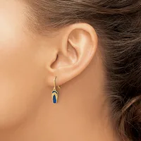A person wearing a small gold-toned drop earring with a blue stone or enamel detail, shown from the side profile of their ear.