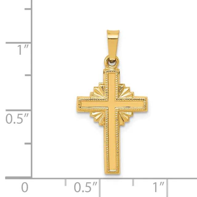 A gold cross pendant with decorative shell-motif designs on the sides, shown next to a ruler indicating its size is approximately one inch tall.