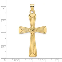 Gold cross pendant with radiating linear details and a small circular center medallion, shown against a ruler measuring approximately 2 inches in length.