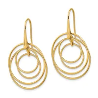Pair of gold concentric circle drop earrings with wire hooks, shown on white background.