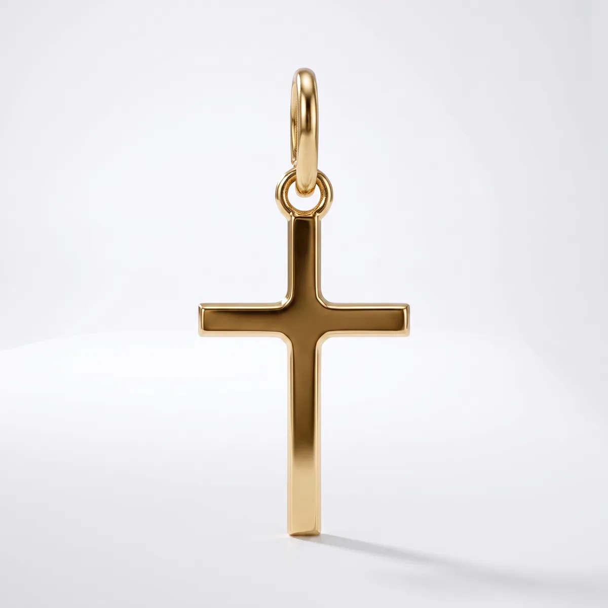 A polished gold cross pendant with a rounded bail loop at the top, displayed against a white background.