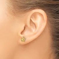 A small gold star-shaped stud earring with an open twisted design worn on a person's earlobe.