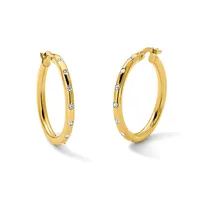 A pair of gold hoop earrings with diamond accents spaced around the outer surface, shown from a front-facing angle.